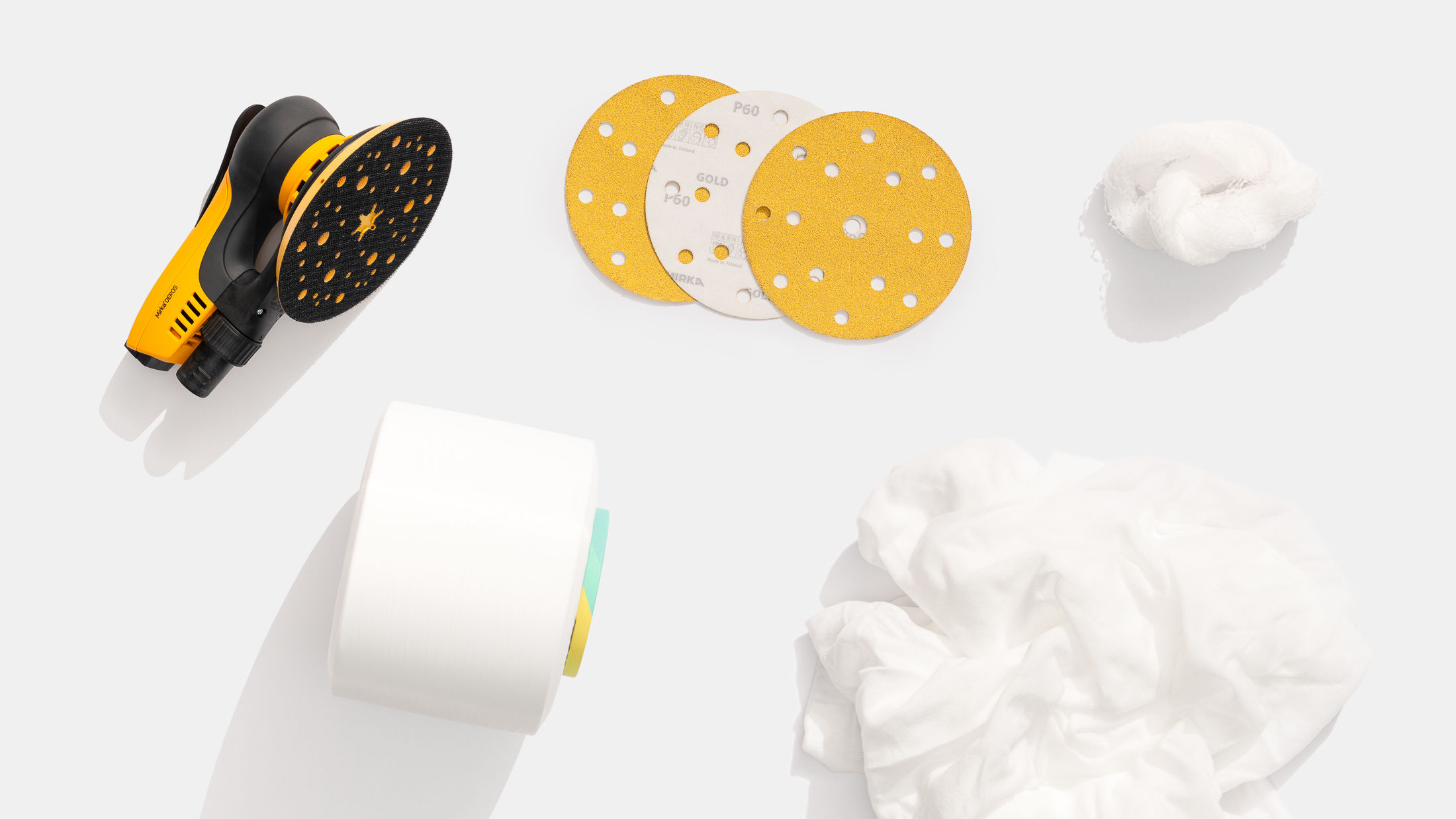 Lijadora DEROS y abrasivos Mirka con textiles reciclados sobre un fondo blanco