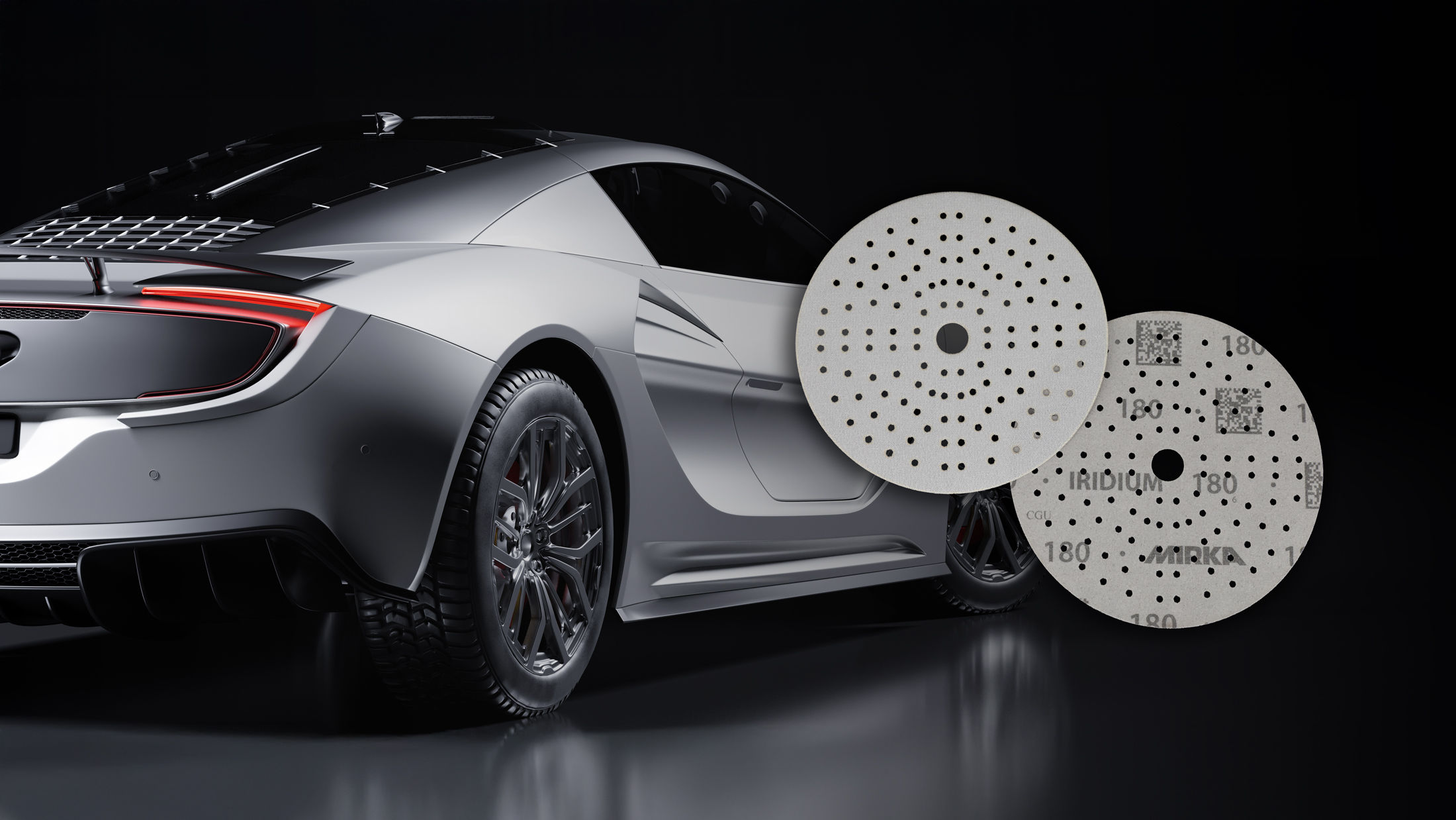 Discos Iridium Soft com um carro desportivo ao fundo