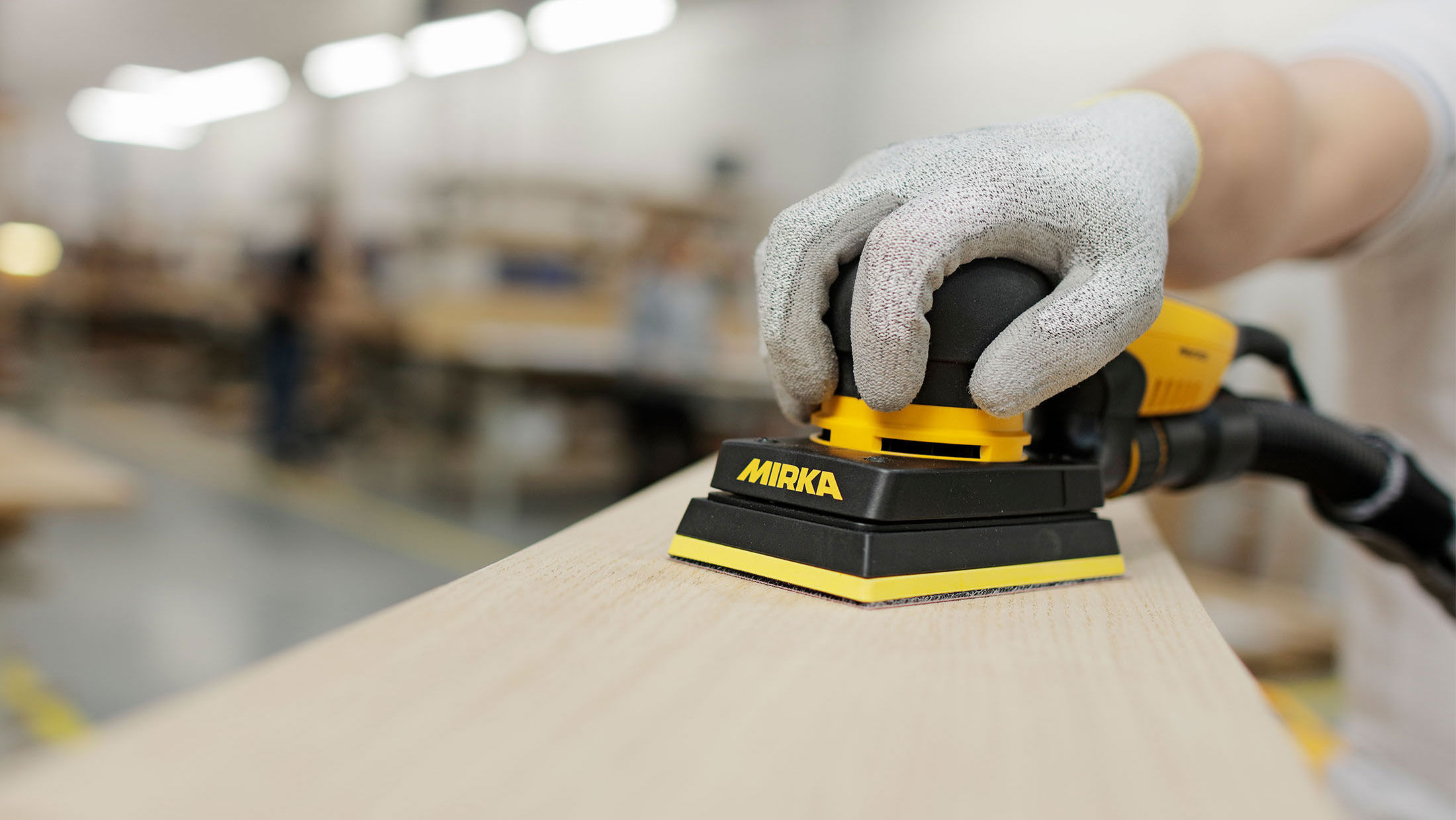Wood sanding in a workshop with a Mirka DEOS sander
