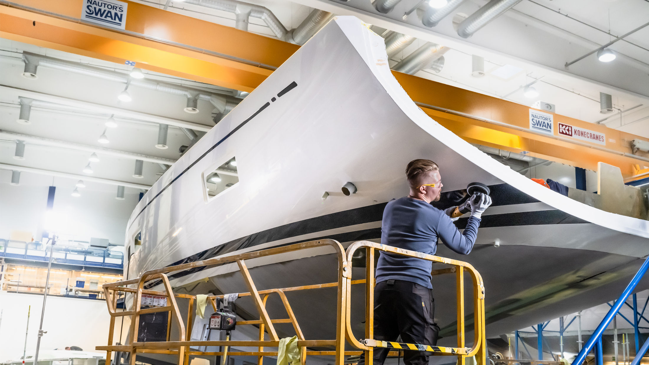 Man sanding a yacht with a Mirka polisher.